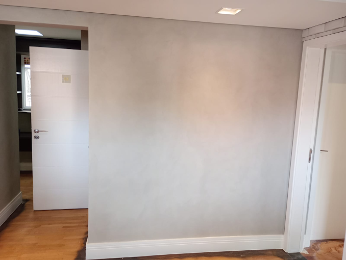 Parede em cimento queimado com portas brancas